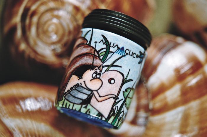 AquaClic Strahlregler Giardino mit handgezeichnetem Gartenmotiv mit Schnecke und Pflanzen als dekorative Produktaufnahme, auf hintergrund mit Schneckenhäusern