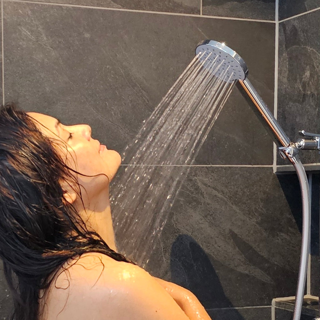 junge Frau duscht wassersparend mit der Aquaclic-Prosecco-Duschbrause