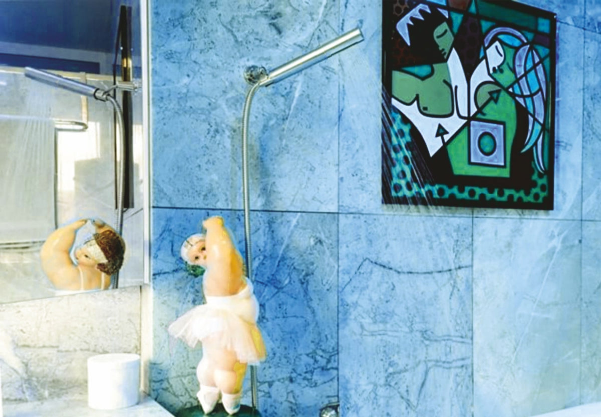 L'élégante douchette en acier inoxydable dans une salle de bains avec des plaques de marbre gris et une figure de danseuse