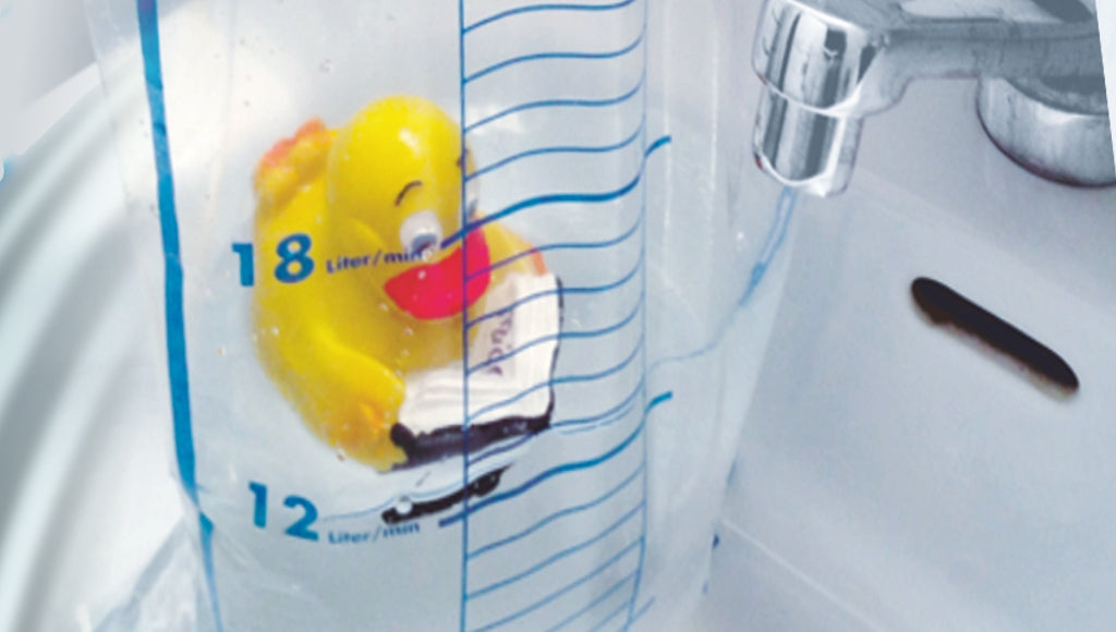 Messbeutel mit Badeentchen in einem Lavabo umd den Wasserdurchfluss zu messen