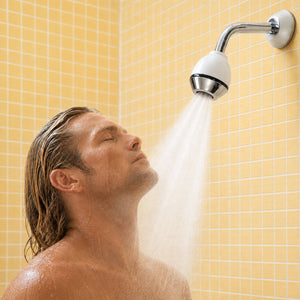 Junger Mann unter der Wandbrause EcoClima verchromt-weiss von AquaClic mit Turbulenzstrahl