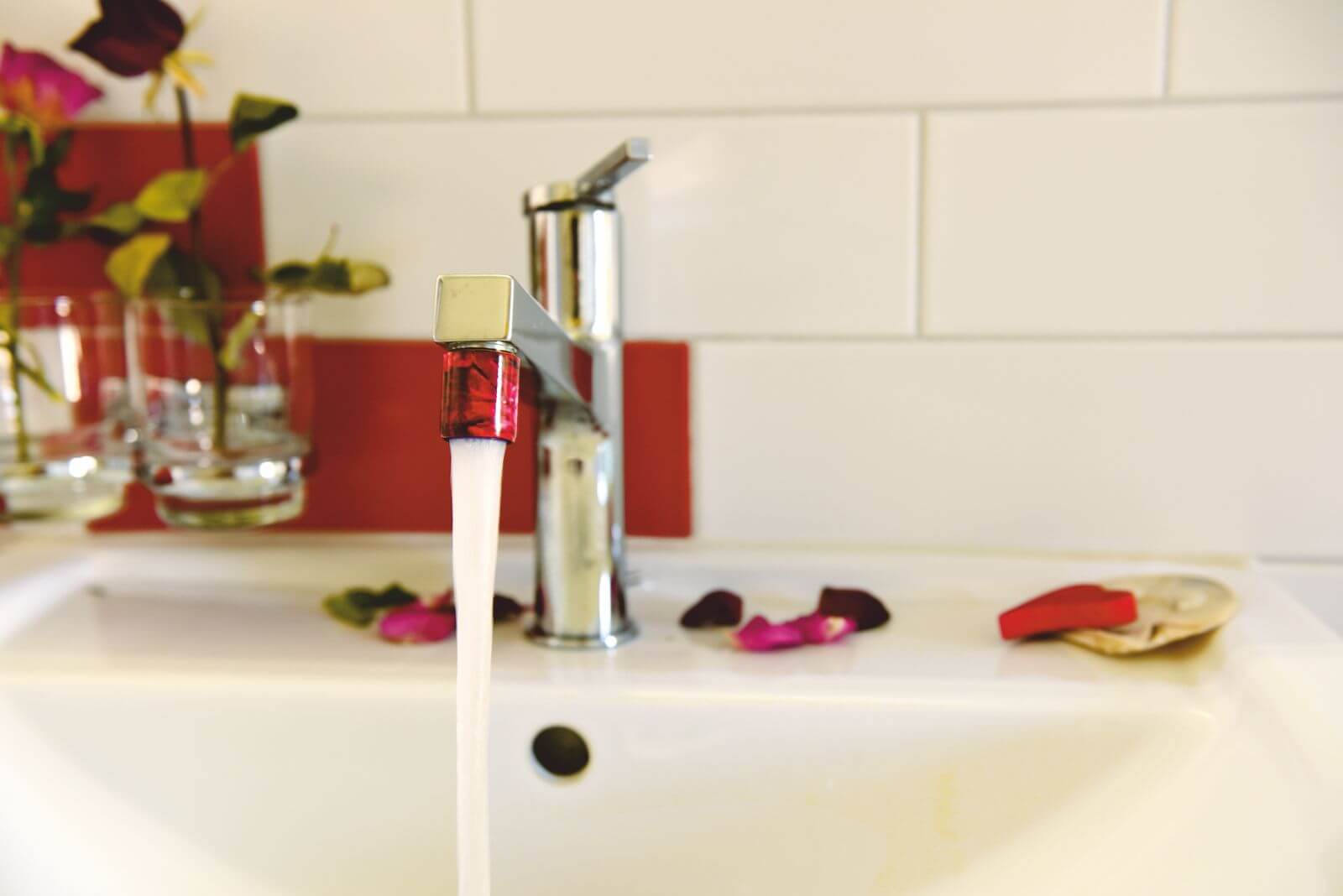 Wasserhahn mit montierter AquaClic Brause in Pink – Detailansicht der einfachen Montage ohne Werkzeug